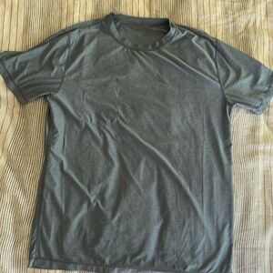 Large Sky Blue Vuori Men’s Tradewind Performance workout shirt with pocket.